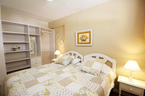 sypialnia z białym łóżkiem z poduszkami w obiekcie Apartment Acapulco Ocean View w Playa de las Americas