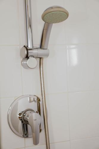 a shower with a shower head and a sink at Ibis Budget Girona Costa Brava in Girona