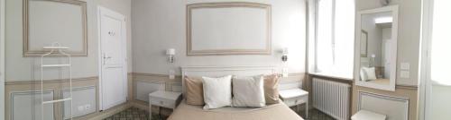 um quarto com uma cama com almofadas e um espelho em - Home Sweet Langhe - Room 51 em Alba