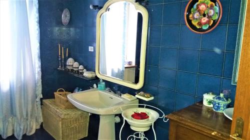 a blue tiled bathroom with a sink and a mirror at Villa Maria Sole in Revello