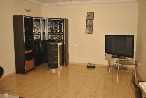 a living room with a television and a large refrigerator at Résidence Hotelière Borel Denver in Douala