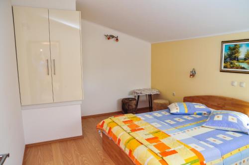 Apartments Toska في راب: غرفة نوم مع سرير وخزانة بيضاء