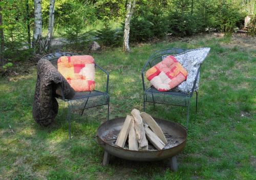 two chairs and a fire pit in a yard at Bahnhof Droyßig - Übernachten im Denkmal in Droyßig