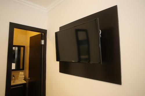 a flat screen tv on the wall of a bathroom at Aranjuez Hotel & Suites in David