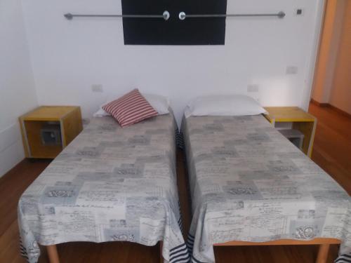 トリノにあるLuoghi Comuni Porta Palazzoのベッド2台が隣同士に設置された部屋です。