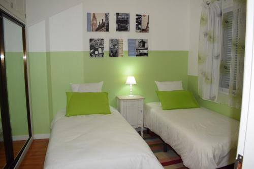 duas camas num quarto com paredes verdes em Bay View Apartment no Funchal