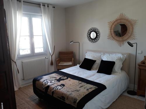 a bedroom with a bed and a mirror and a window at Maison de ville style échoppe in Le Bouscat