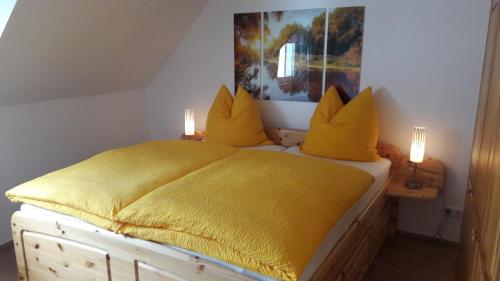 コッヘムにあるHaus Madleのベッドルーム1室(黄色いシーツと照明2つ付)