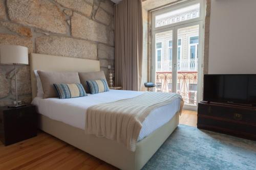 ein Schlafzimmer mit einem großen Bett und einem TV in der Unterkunft Oporto City View - Santo Ildefonso Luxury in Porto