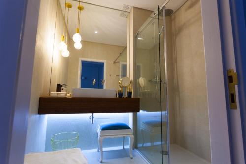 ein Bad mit einem Waschbecken und einer Glasdusche in der Unterkunft Oporto City View - Santo Ildefonso Luxury in Porto