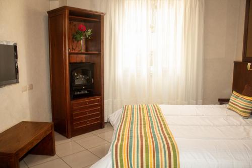 a bedroom with a bed and a dresser and a television at O2 Hotel Buenos Aires in Buenos Aires