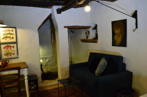 a living room with a blue chair and a table at Casa Messi in Pitigliano