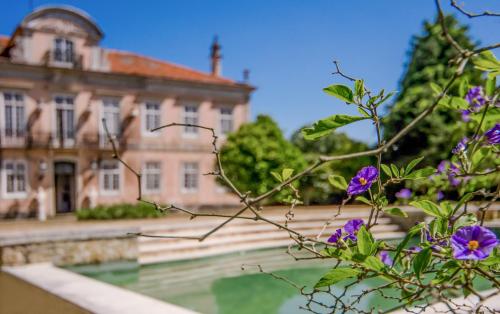 an old building with purple flowers in front of it at Quinta do Tojal in Ferreira do Zêzere