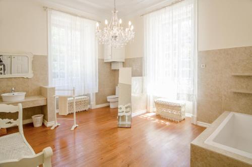 a bathroom with a chandelier and a wooden floor at Quinta do Tojal in Ferreira do Zêzere