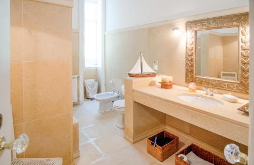 a bathroom with a sink and a toilet and a mirror at Quinta do Tojal in Ferreira do Zêzere