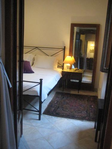 a bedroom with a bed and a mirror and a lamp at Casa Messi in Pitigliano