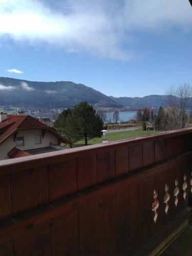 a fence with a view of a lake and mountains at Ossiachersee Apartments in Steindorf am Ossiacher See