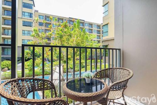 a patio with two chairs and a table on a balcony at Rain Cha-am Huahin By Sake in Cha Am