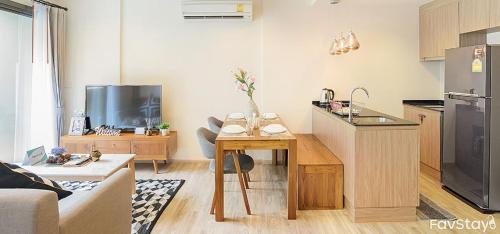 a living room with a kitchen with a table and a living room at Rain Cha-am Huahin By Sake in Cha Am