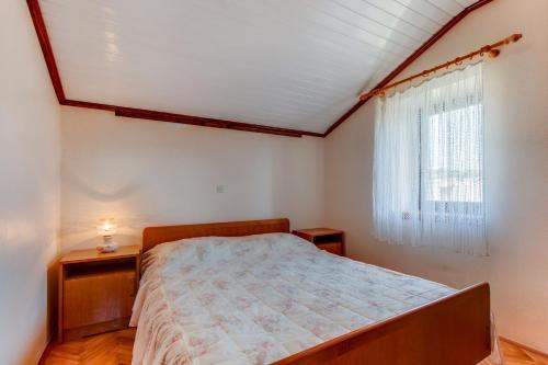a bedroom with a bed and a window at Apartment Danilo in Mali Lošinj