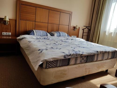 モスクワにあるDeluxe Apartment on Severnoe Chertanovoのベッドルーム1室(大型ベッド1台、木製ヘッドボード付)