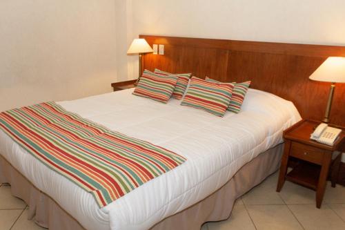 a bedroom with a large white bed with two pillows at O2 Hotel Buenos Aires in Buenos Aires