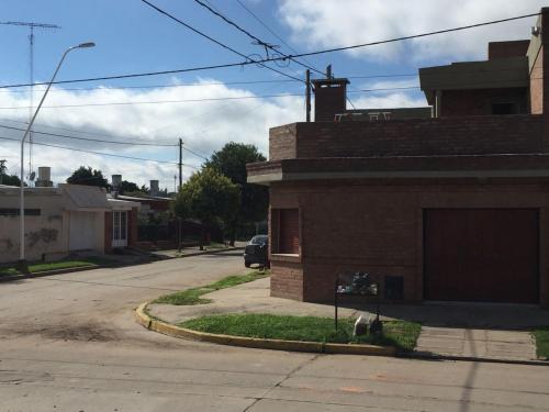 un perro sentado al lado de un edificio en una calle en Casa Nuova Depto CERO en Villa María