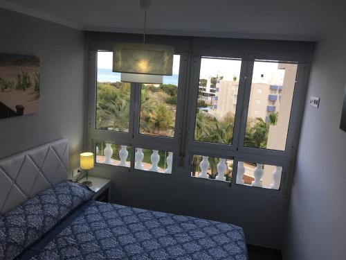 グアルダマル・デル・セグラにあるMimosa Apartmentのベッドルーム1室(窓2つ、ベッド1台、ランプ付)
