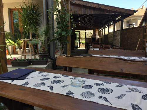 a patio with a table and benches and plants at Guest House Niya Chernomorets in Chernomorets