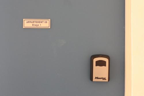 un panneau sur un mur avec un téléphone dessus dans l'établissement Appartement N°8 Vue Mer, Perros Guirec, à Perros-Guirec