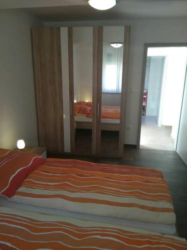 a bedroom with a large bed and a mirror at Apartment Luzia in Banjole