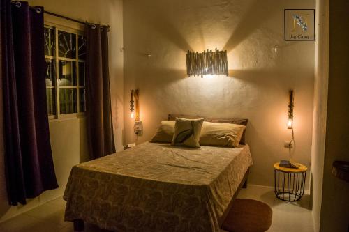 a bedroom with a bed in a room with lights at La Casa de Ñaña in Holbox Island