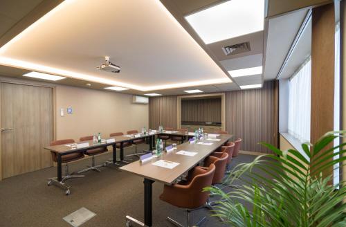 a conference room with long tables and chairs at Mercure Poitiers Centre in Poitiers
