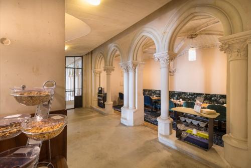 a large room with columns and aasteryasteryasteryasteryasteryasteryasteryasteryastery at Mercure Poitiers Centre in Poitiers