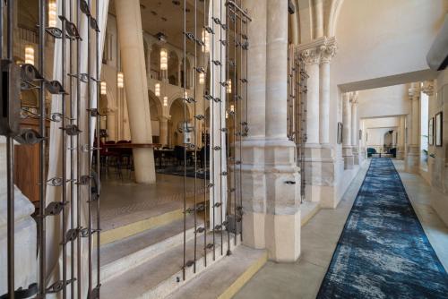 a hallway in a building with columns and glass doors at Mercure Poitiers Centre in Poitiers