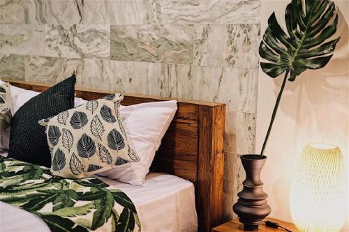 a bedroom with a bed with a plant on a table at Rain Cha-am Huahin By Sake in Cha Am
