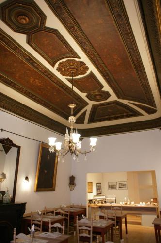 a dining room with a coffered ceiling and tables and chairs at Hostal Plaja i Pati de Can Plaja in Palafrugell