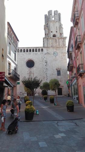 a large stone building with a tower on a street at Hostal Plaja i Pati de Can Plaja in Palafrugell