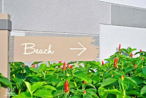 a sign for a bush with red flowers at Rain Cha-am Huahin By Sake in Cha Am
