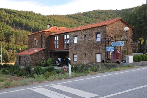 a large brick house on the side of a road at Casa Lagar Da Alagoa in Manteigas
