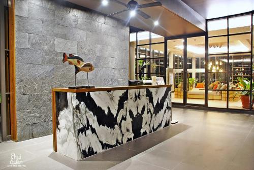 a lobby with a counter with a bird on it at Rain Cha-am Huahin By Sake in Cha Am