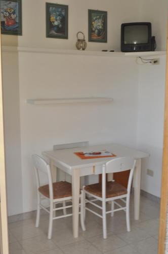 a white table with two chairs and a tv at Residence Belvedere in Capoliveri