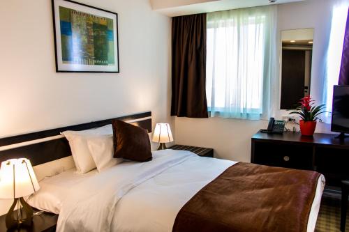 a hotel room with a bed and a window at Best Western Hotel Galla in Pristina