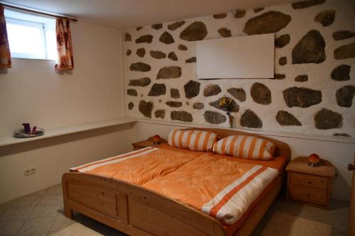 a bedroom with a bed and a rock wall at AktivQuartier Mühlviertel Apartment in Oepping