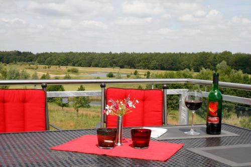 una mesa con una botella de vino y dos copas en Villa Harmonie W2, en Göhren-Lebbin