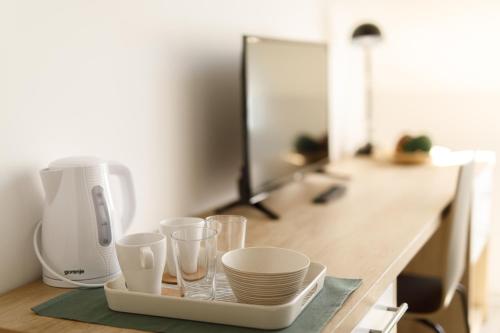 a tray with plates and cups on a counter with a mixer at Arhiv Boutique House in Novi Sad
