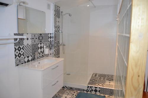 a white bathroom with a shower and a sink at L'Oléastre en Luberon in Grambois