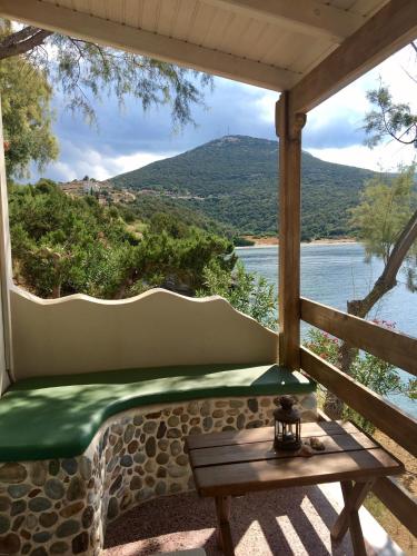 a bench on a porch with a view of the water at Venus Beach Hotel in Nea Stira