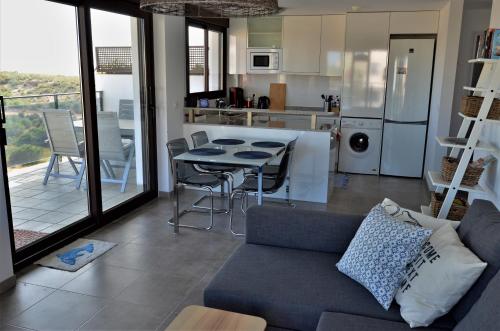 アレナレス・デル・ソルにあるFamily Apartmentのリビングルーム(ソファ、テーブル付)、キッチンが備わります。