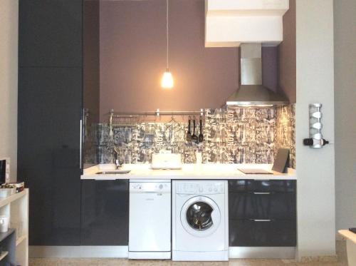 a kitchen with a washing machine and a sink at Sweet Home Alameda in Seville